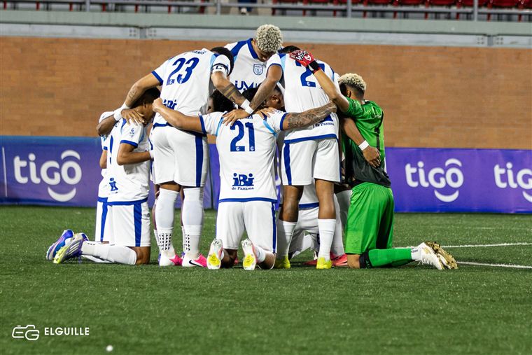 Equipo de fútbol en círculo celebrando en la cancha